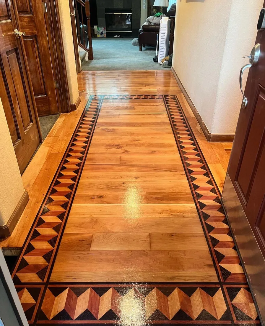 Hallway floor framed by a decorative inlaid border in contrasting woods