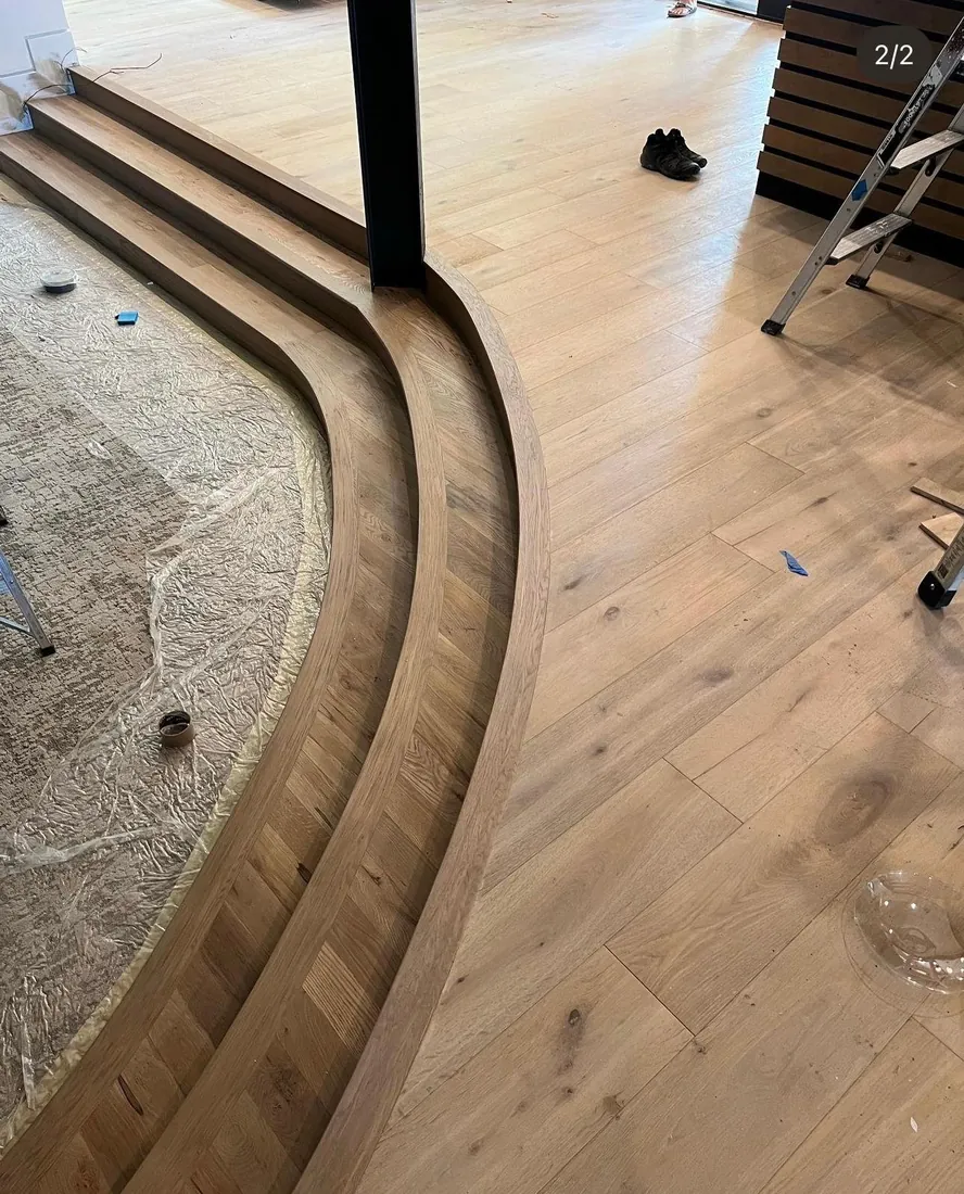 Curved radius hardwood planks bent around the base of a staircase
