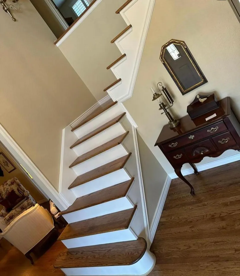 Staircase with wood treads and painted white risers seen from the landing